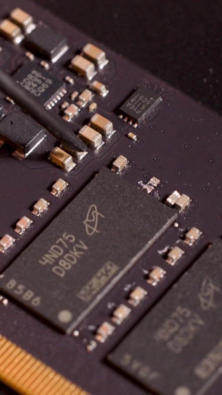 Nærbillede af håndværktøj, der peger på en mikrochip på et kredsløbskort, makroobjektiv, blød studiebelysning