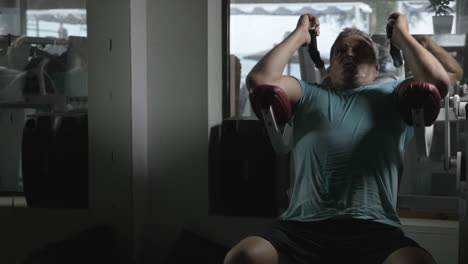 mature man using situps machine in the gym