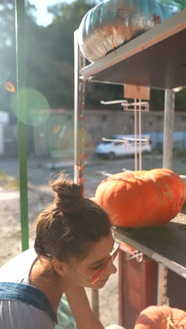 mujer mirando calabazas en un mercado al aire libre