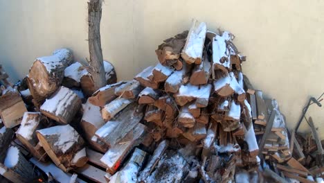 Chopped-fire-wood-on-the-side-of-the-house-covered-in-snow-during-the-winter