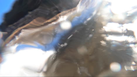 POV-from-within-the-surf-being-buffeted-around-within-the-waves-surrounded-by-sand-and-bubbles-and-wave-froth