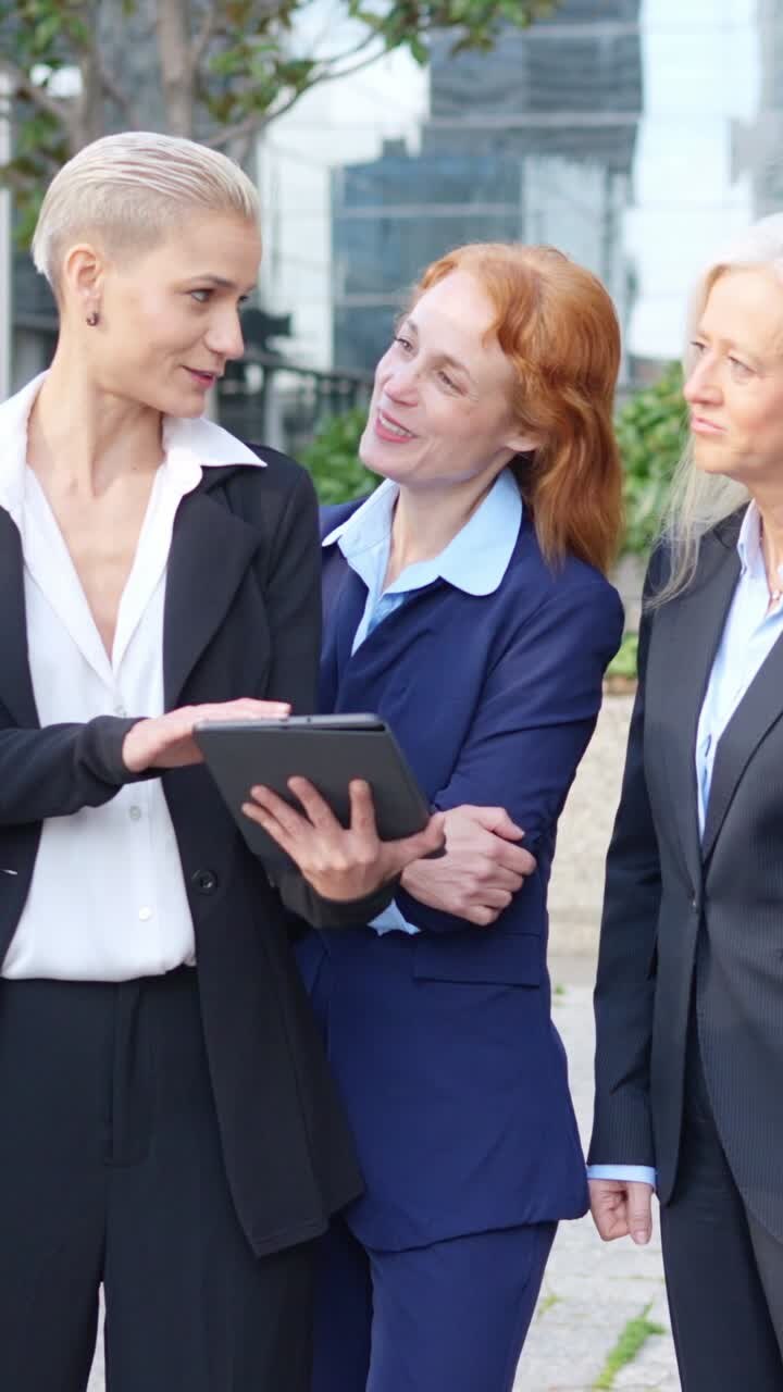 Professional Women Collaborating on a Tablet Outdoors
