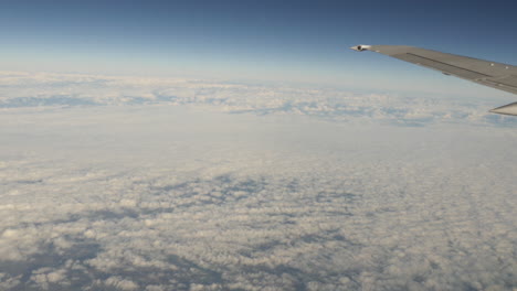 aerial view of clouds out of plane window with wing shot in 4k high resolution