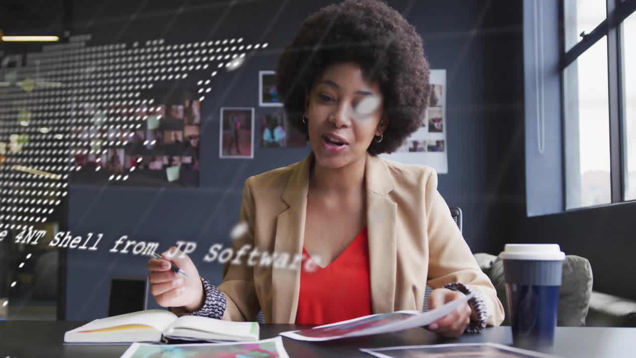 Animation of data processing, world map over biracial businesswoman having video call in office