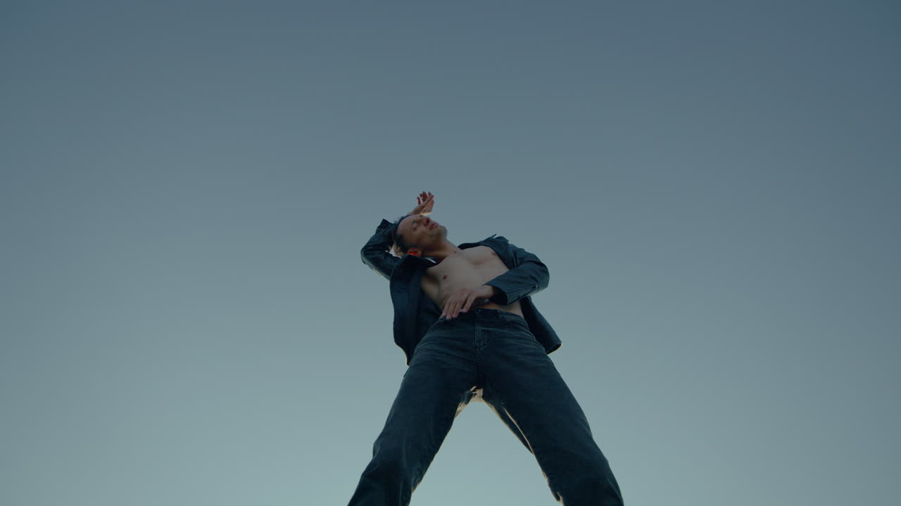 검은색 가죽 재을 입은 남자가 춤을 추고, 지붕, 높은 건물, 넓은 각도, 느린 동작