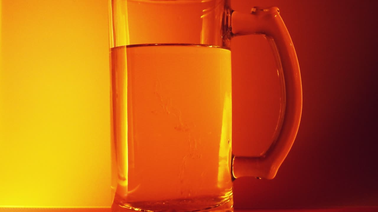 Honig in ein Glas Wasser gießen vor goldenem Hintergrund
