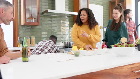 Happy-diverse-male-and-female-friends-preparing-food-together-in-kitchen