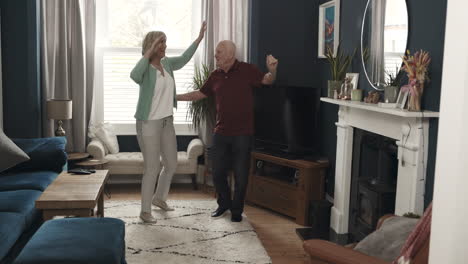 senior couple dancing in living room