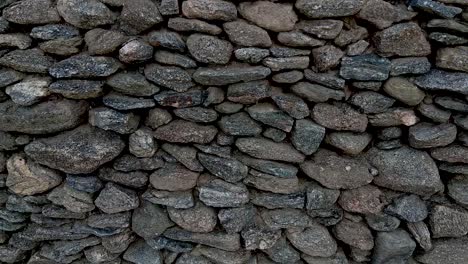 close up panning shot of a hand-built asymmetrical stone wall