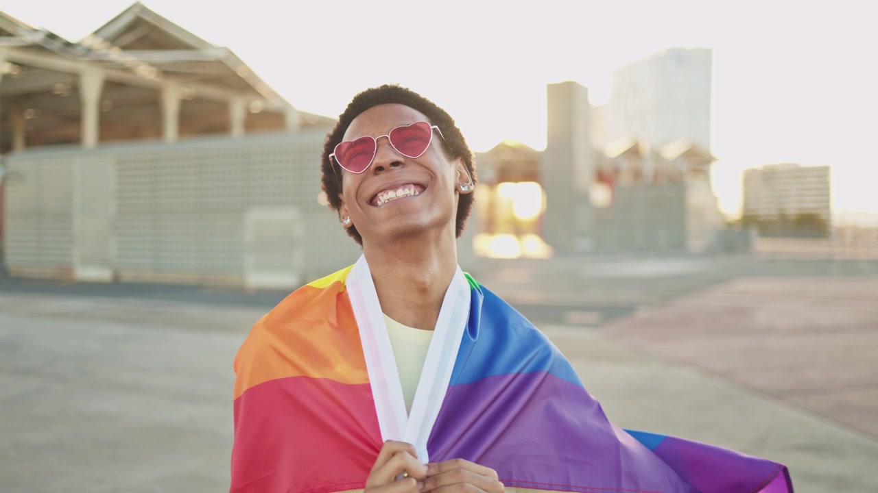 Joyful Young Person with Rainbow Pride Flag and Heart Sunglasses