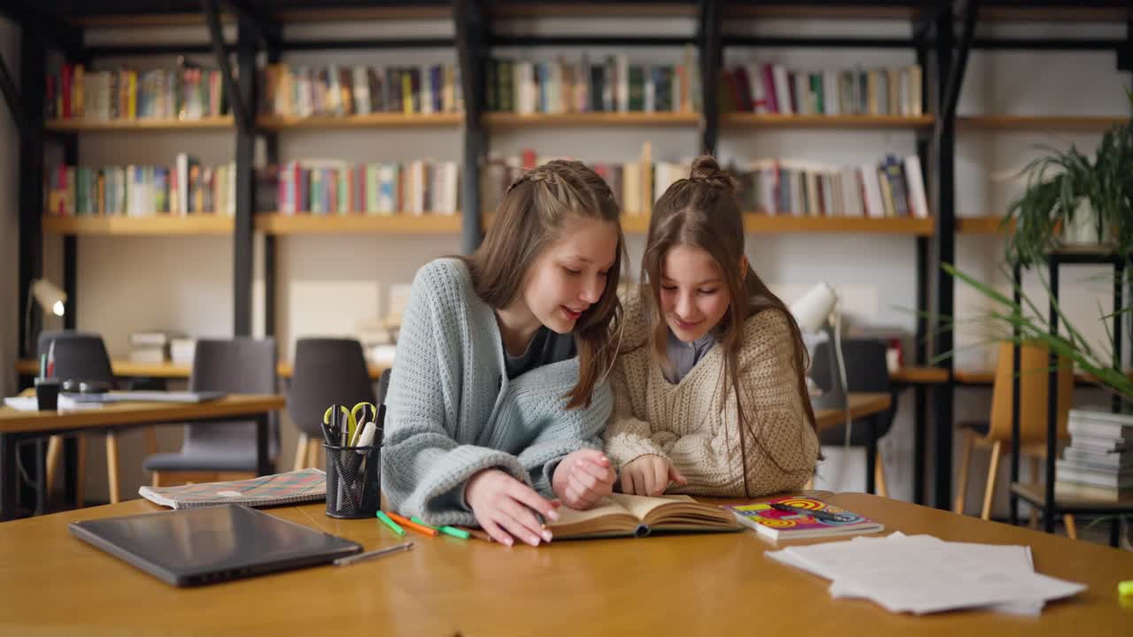 Tenåringsjenter studerer på et bibliotek