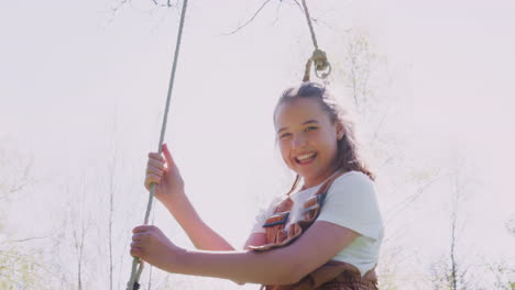 retrato de una chica divirtiéndose en un columpio de neumáticos en el jardín de su casa