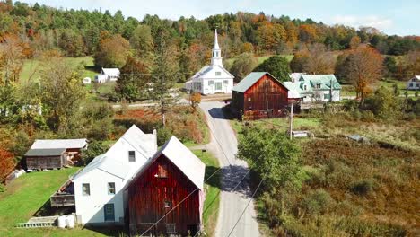 an aerial over a charming small village scene in vermont with church road and farm