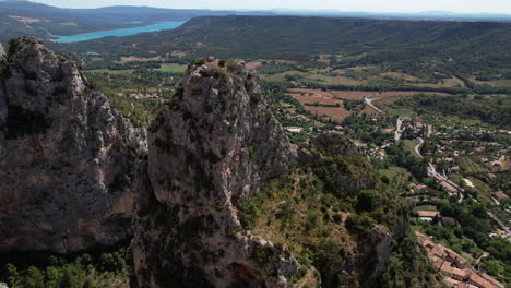 Discovering-Moustiers-Sainte-Marie-village-along-mountains-aerial-shot-sunny-day