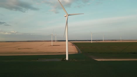rotating blades over windmill farm for alternative power generation. aerial ascending shot
