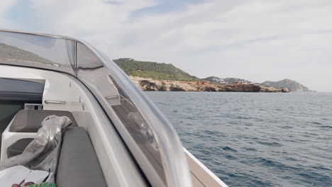 traveling from the bow of a luxury boat, and the backgroud the coast of ibiza, spain