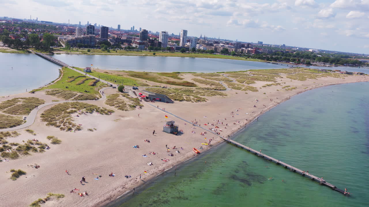 Aerial drone view of Amager Strandpark beach and dunes, with the Copenhagen skyline visible in the distance