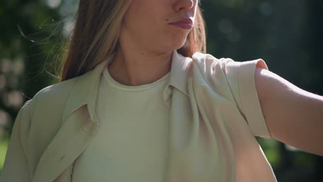 close-up of woman flexing her arm in strong, confident pose, wearing biker gloves, with green, blurred natural background, her expression and pose convey empowerment