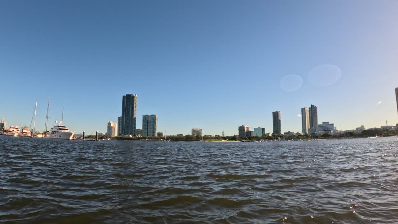 물에서 골드 코스트 스카이 라인 위의 일몰