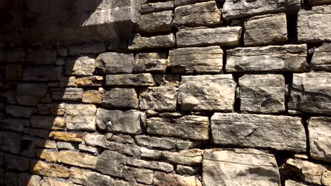 very old wall made out of stone bricks crumbling 4k panning