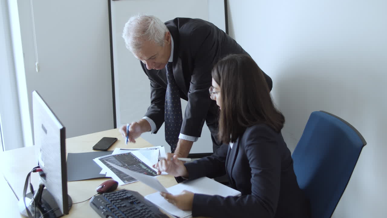 Serious mature financial experts explaining chart details