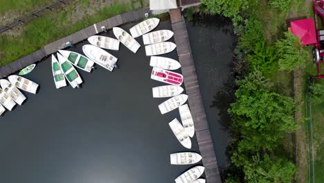 aerial view of small boats moored by the wooden jetty in the lake