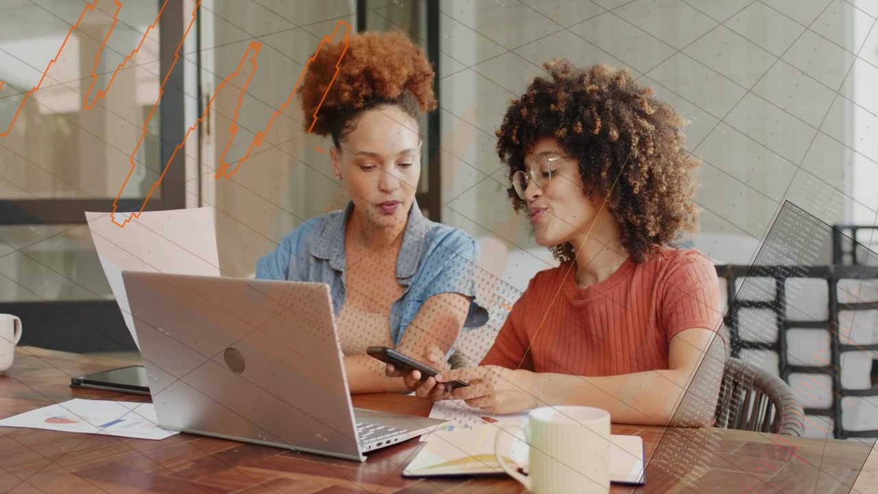 Two coworkers sitting at table right-side woman sliding phone comparing business charts and calling