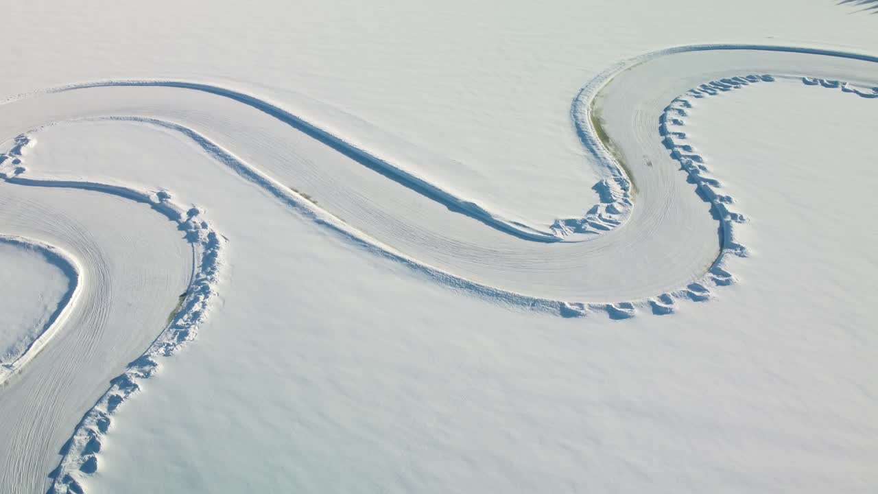 Part of a Race track on a Frozen Lake in Finland during golden hour – Aerial Winter Landscape top down
