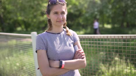 portrait of an attractive smiling caucasian woman in a park with glasses