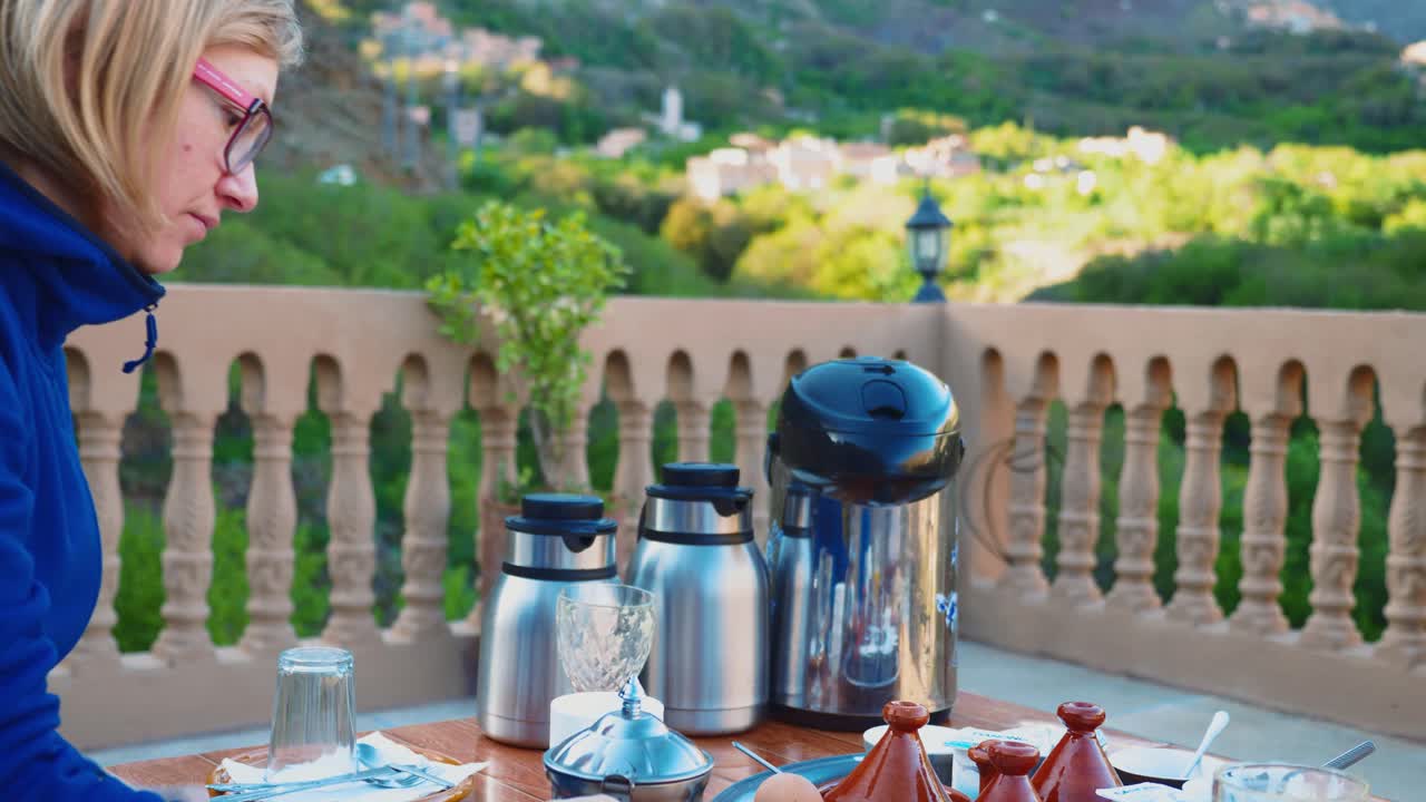 Blond turistflicka som äter typisk marockansk frukost i Höga Atlasbergen.