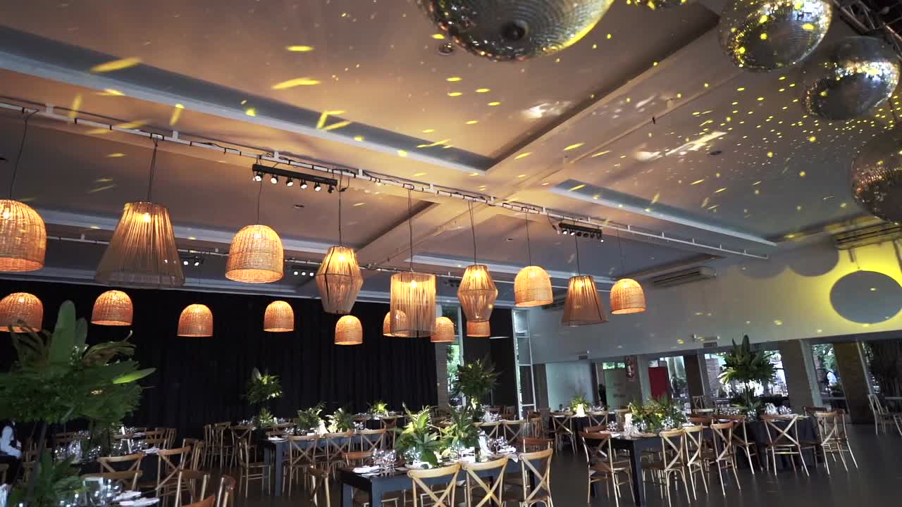 아름다운 테이블 설정, 매달린 램프, 그리고 디스코 공으로 축제 분위기를 만드는 우아한 결혼식 리셉션