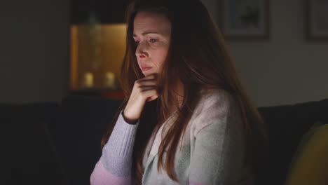 Anxious-Woman-Sitting-On-Sofa-At-Home-At-Night-Looking-At-Laptop-Concerned-About-Social-Media-Or-Bad-News-11