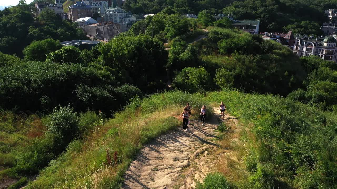 mujeres corriendo en un sendero con vistas al paisaje urbano