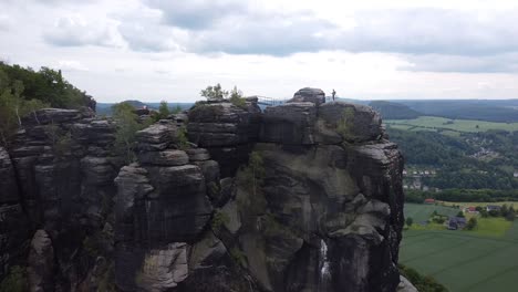 man on the silver mountain as drone rises high with massive rock formation close to the czech border comes into view