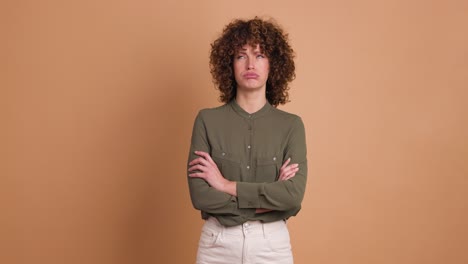 disagreeing young woman shaking head with twisted mouth on beige background