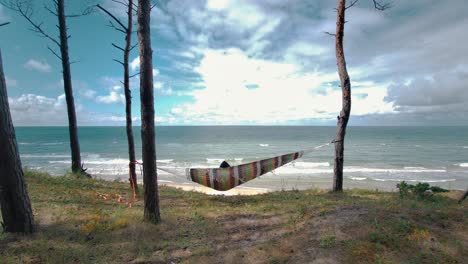 relaxing in the hammock by the windy baltic sea and enjoying sea view stedicam shot