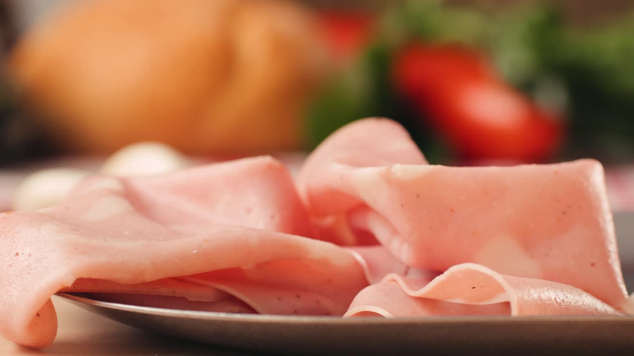 Ham italian mordatella, man Slices Of Traditional Italian antipasti mortadella sausage on a wooden cutting board, close up macro of chicken or turkey jamon, fat breakfast dish.