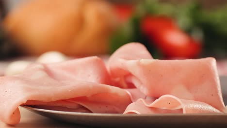 ham italian mordatella, man slices of traditional italian antipasti mortadella sausage on a wooden cutting board, close up macro of chicken or turkey jamon, fat breakfast dish.