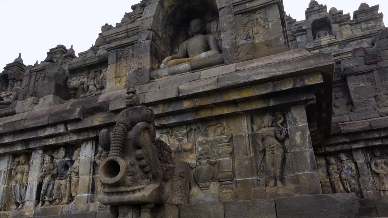 Borobudur Buddhist Temple In Indonesia, Exterior View Of Ancient Stone Wall Carvings And Buddha Statues