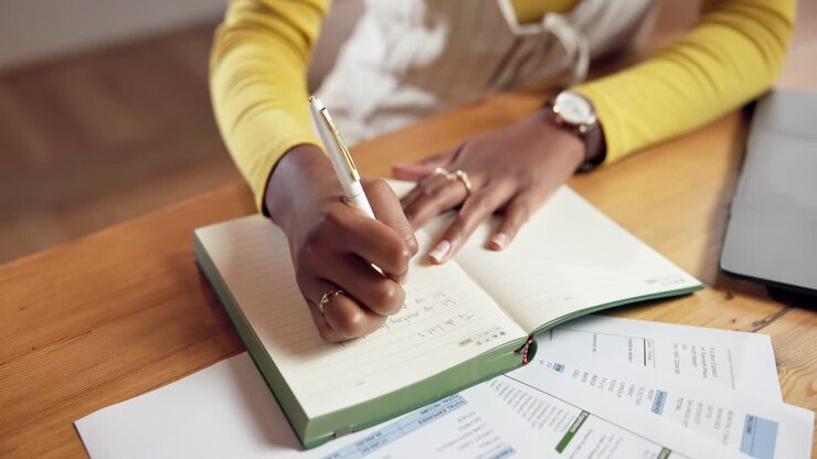Woman writing in a notebook at a desk