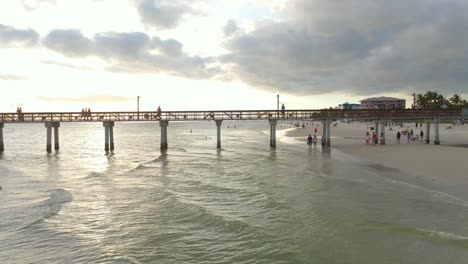 tourist walking on fort myers beach pier in florida during sunset