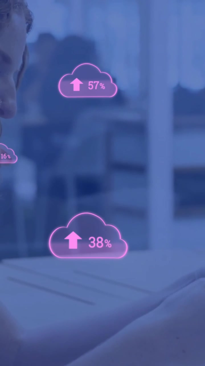 Animation of pink clouds uploading data over caucasian businesswoman using smartphone and laptop
