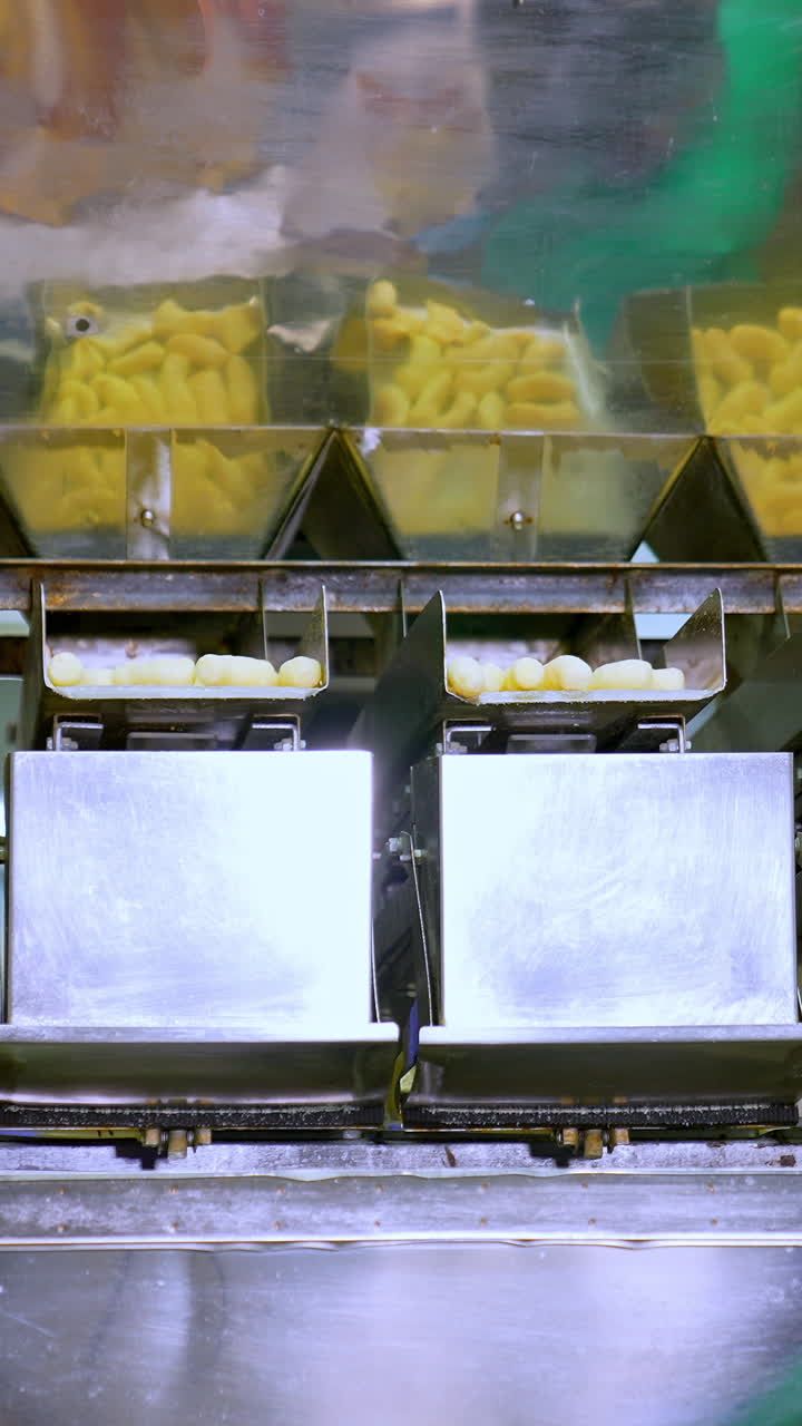 Factory conveyor full of crispy puffcorn. Corn sticks factory making. Vertical video