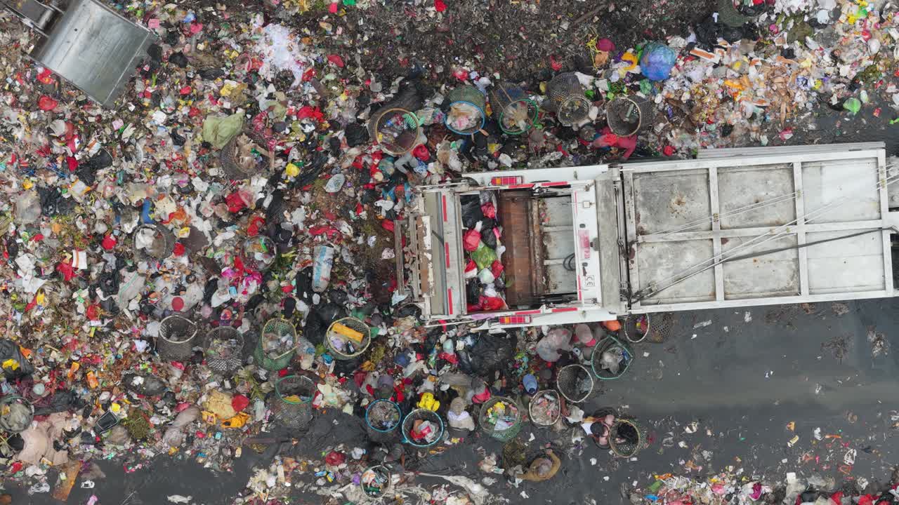 Autocompattatore che scarica in una discarica sovraffollata a Jakarta.