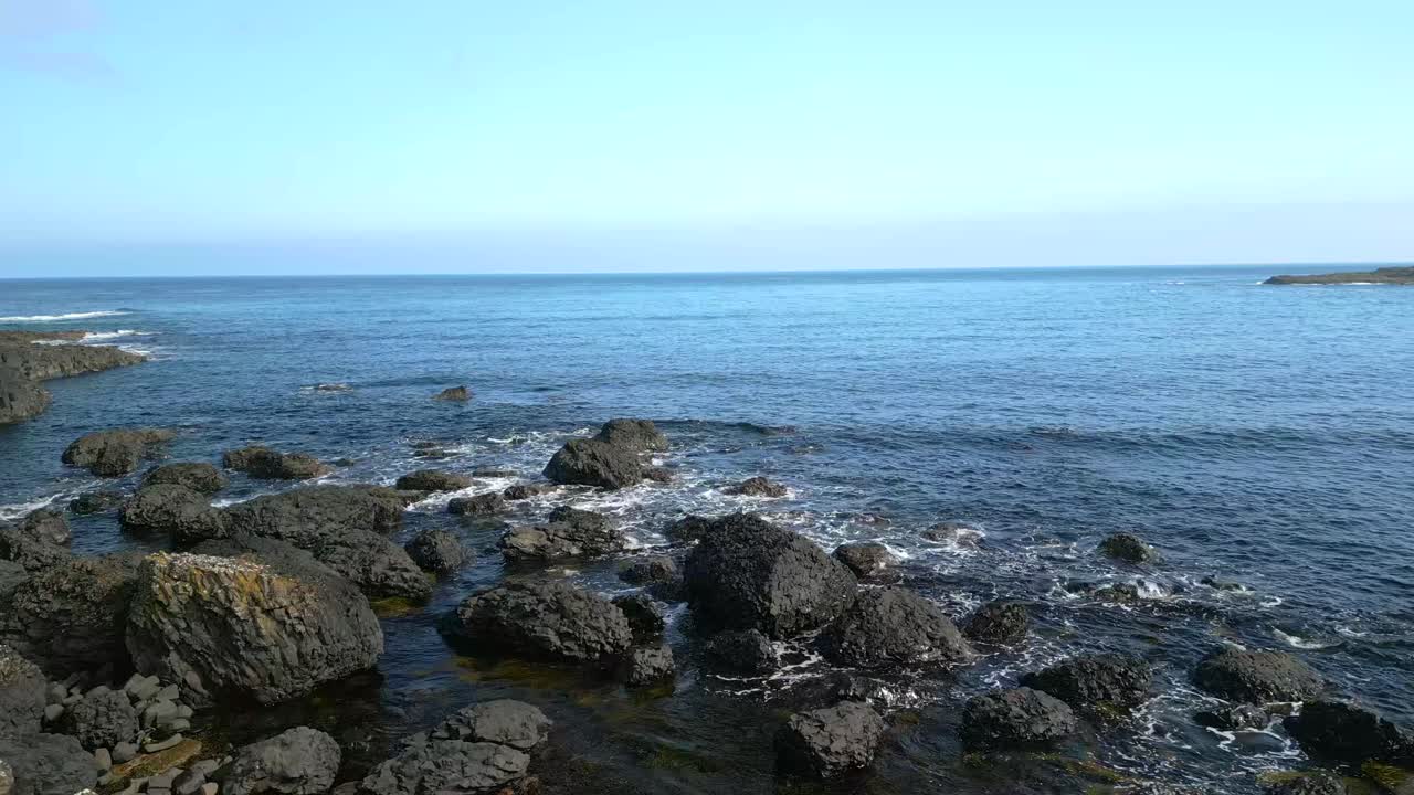Luftfoto af kystlinjen ved Giant's Causeway i County Antrim, Nordirland ved solopgang