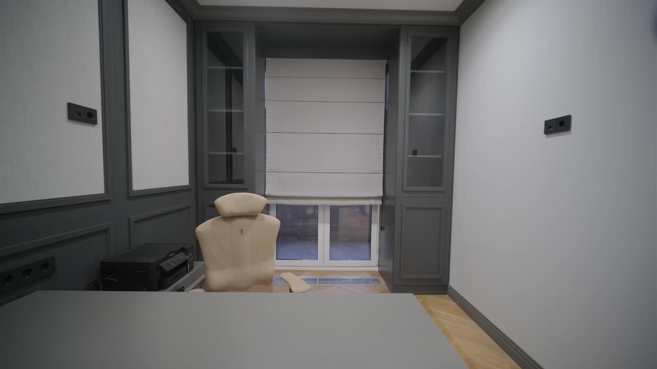 oficina en casa elegante con paneles oscuros, un elegante escritorio y un juego de sillas, y un piso de madera de hueso de pescado