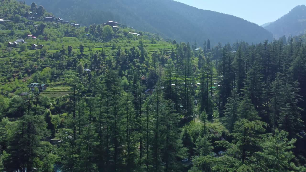 Aerial view short of Jibhi Himachal Pradesh in India. Houses and trees in the mountainous area. Faguli festival is one of the biggest festival in Jibhi. The traditional houses here have stone roofs.