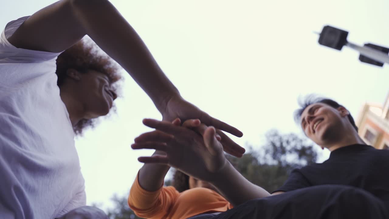 Happy multiethnic friends stacking hands for success