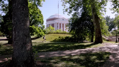 a student walks on the lawn towards the rotunda at the university of virginia