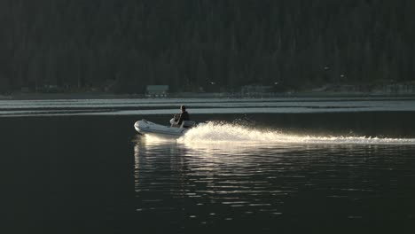 Hombre-En-Lancha-Navegando-En-La-Laguna-Marina-Cerca-De-La-Costa-De-Alaska-En-La-Tarde-Soleada,-Vista-Amplia-En-Cámara-Lenta